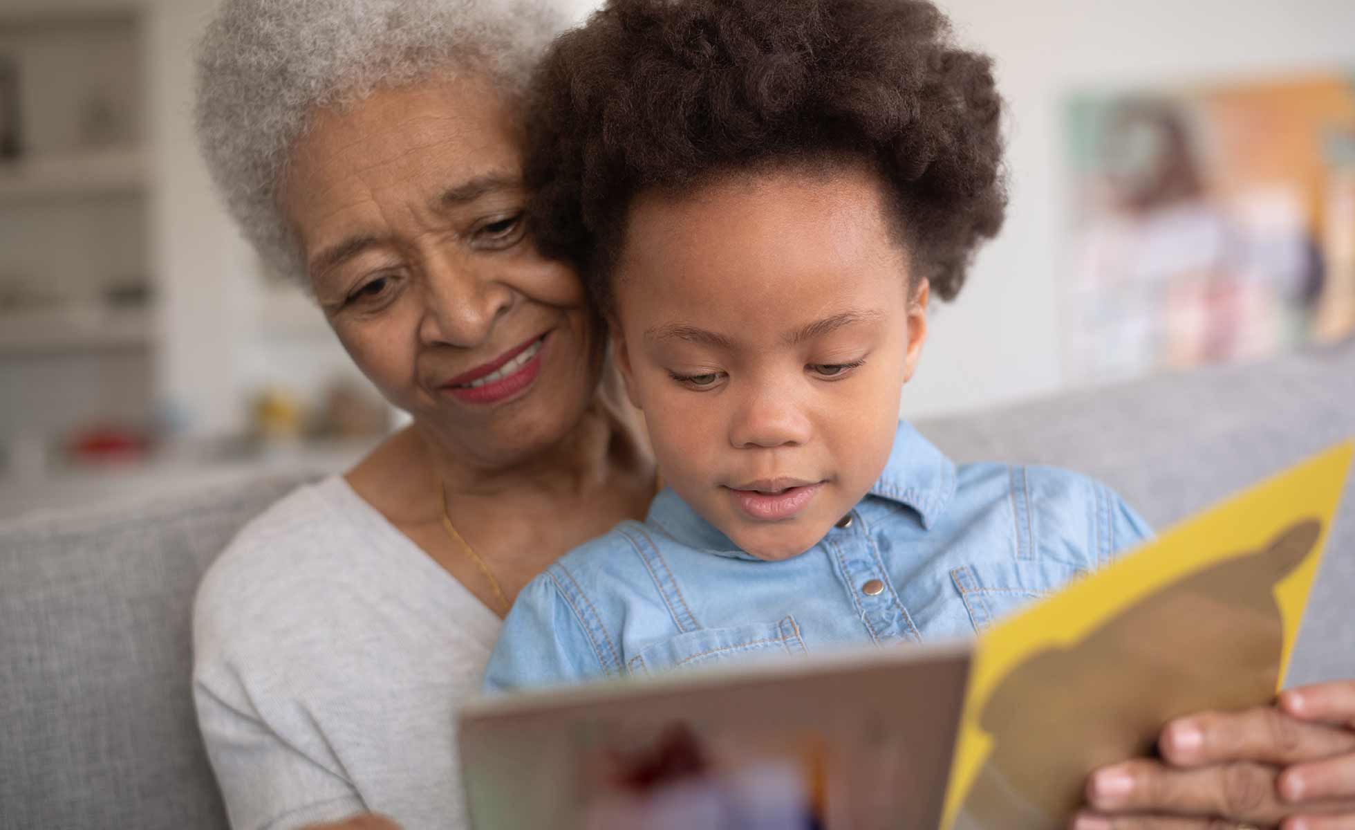 Photo of grandmother and her granddaughter reading a book